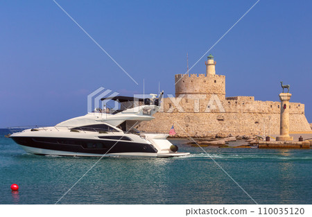 Old stone lighthouse illuminated by the sun at Fort St. Nicholas in Rhodes. 110035120