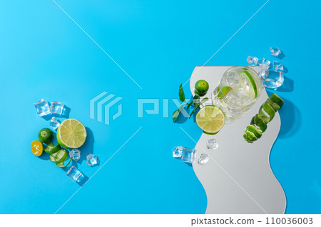 A wave-shaped acrylic sheet displayed on a blue background with ice, lemon and fresh kumquat. Applying lemon to treat acne and brighten the skin thanks to the high antioxidant properties of lemon. A wave-shaped acrylic sheet displayed on a blue background with ice, lemon and fresh kumquat. Applying lemon to treat acne and brighten the skin thanks to the high antioxidant properties of lemon. 110036003