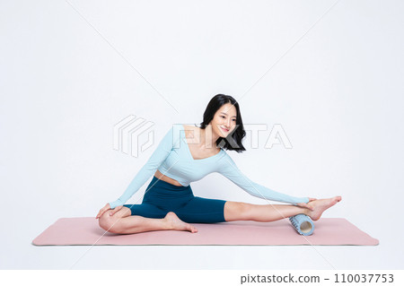 photo of a woman stretching using a hellse beauty foam roller 110037753