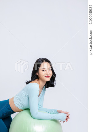 Healyh Beauty_woman leaning on a gym ball 110038625