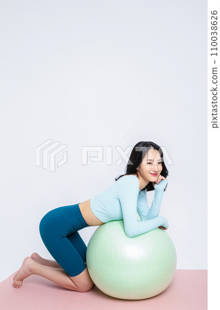 Healyh Beauty_woman leaning on a gym ball 110038626