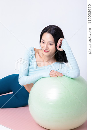 Healyh Beauty_woman leaning on a gym ball 110038630