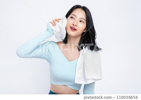 There is a woman who wipes her face's sweat with a towel in her hand 110038658