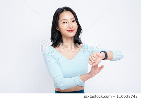 The woman is holding a watch on her watch The woman is holding a watch on her watch 110038742