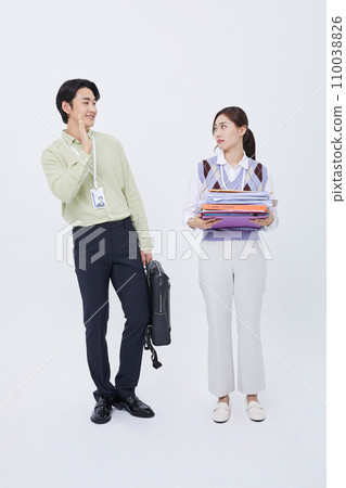 man leaving work greeting a woman holding a lot of documents man leaving work greeting a woman holding a lot of documents 110038826