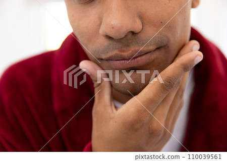 Biracial man touching his face in bathroom at home Biracial man touching his face in bathroom at home 110039561