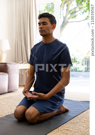 Biracial man doing yoga and meditating at home Biracial man doing yoga and meditating at home 110039567