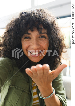 Happy caucasian woman having video call, blowing kiss in sunny room at home 110039656
