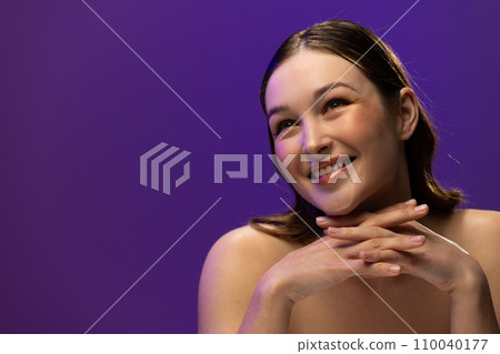 Caucasian woman wearing eyeliner and lip gloss on purple background, copy space Caucasian woman wearing eyeliner and lip gloss on purple background, copy space 110040177