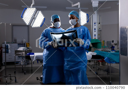 African american male and female doctors with face masks looking at x-rays in hospital 110040790