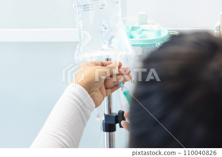 Biracial female doctor preparing drip in sunny hospital room Biracial female doctor preparing drip in sunny hospital room 110040826