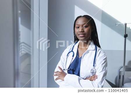 Portrait of happy african american female doctor wearing lab coat in hospital room, copy space 110041405