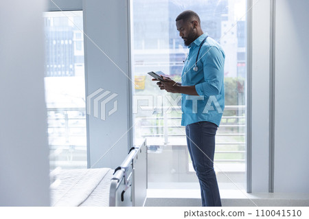 African american male doctor using tablet in hospital room, copy space 110041510