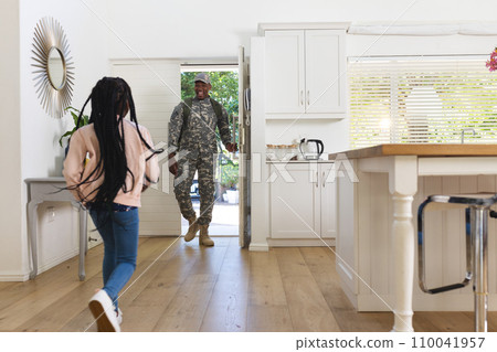Happy african american male soldier meeting daughter at home, copy space Happy african american male soldier meeting daughter at home, copy space 110041957