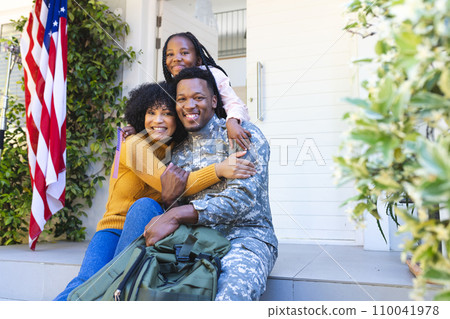 Portrait of happy african american family embracing outside home with usa flag, copy space Portrait of happy african american family embracing outside home with usa flag, copy space 110041978