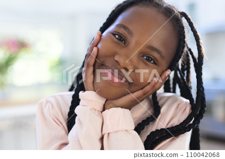 Happy african american girl with hands on face at home, close up, copy space 110042068
