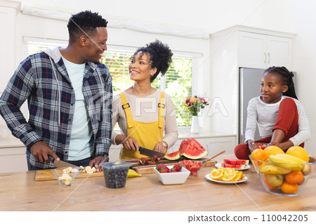 Happy african american family preparing fresh snack from fruits in kitchen at home, copy space 110042205