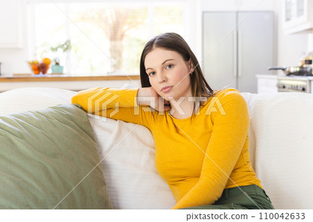 Portrait of thoughtful caucasian woman sitting on couch on in living room at home, copy space 110042633