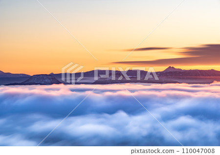 日出的天空下,遠山的山脊線就在雲層之外。 日出的天空下,遠山的山脊線就在雲層之外。 110047008