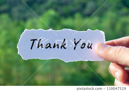 Thank you text on torn white paper with nature background. Thank you text on torn white paper with nature background. 110047529