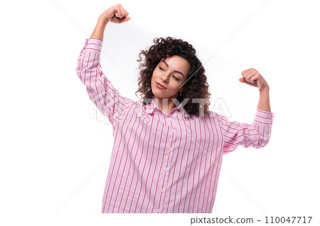 young cute curly-haired caucasian woman dressed in a striped pink blouse actively gesticulates with young cute curly-haired caucasian woman dressed in a striped pink blouse actively gesticulates with 110047717