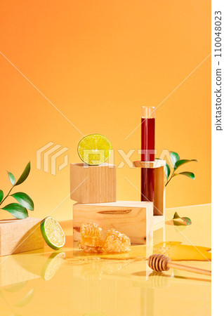 Wooden blocks are artistically arranged with fresh lemons, green leaves and honey on an orange background. Both lemon and honey contain hydrogen peroxide. Wooden blocks are artistically arranged with fresh lemons, green leaves and honey on an orange background. Both lemon and honey contain hydrogen peroxide. 110048023