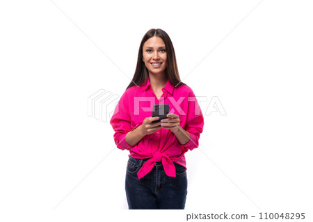 young brunette secretary woman dressed in a pink shirt rejoices holding a smartphone in her hand 110048295