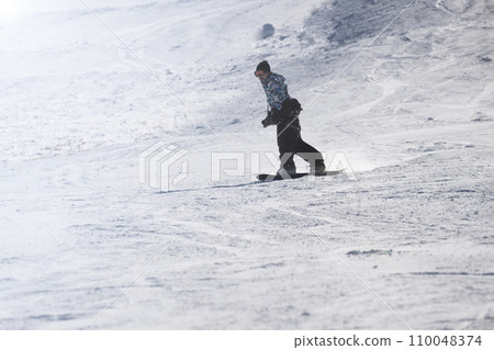 man riding a snowboard 110048374