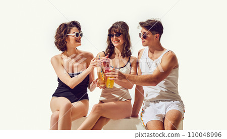 Friendship and love. Beautiful young people, boy and girl in swimsuits and sunglasses, drinking lemonade against white background Friendship and love. Beautiful young people, boy and girl in swimsuits and sunglasses, drinking lemonade against white background 110048996