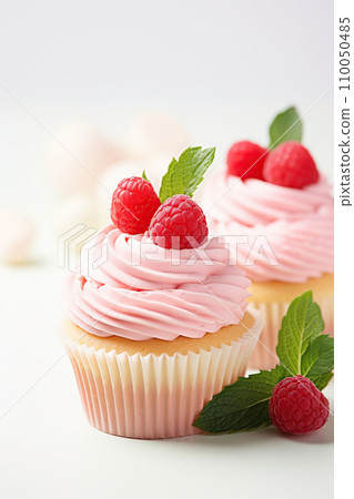 Delicious cupcakes with fresh raspberries and mint on a white background. Generative AI Delicious cupcakes with fresh raspberries and mint on a white background. Generative AI 110050485