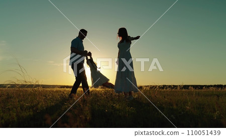 Parents and child playing father spins daughter and gives kid to mother hugs 110051439