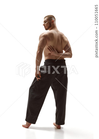 Athletic grace and strength. Rear view portrait of young handsome man posing against white studio background. Body art. 110051665