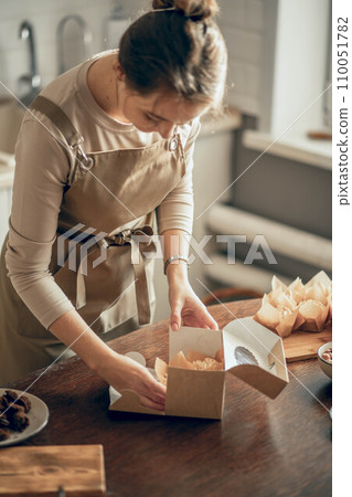 female bakery owner packs boxes for customer's order in birthday, Birthday package. small business entrepreneur and concept of food delivery female bakery owner packs boxes for customer's order in birthday, Birthday package. small business entrepreneur and concept of food delivery 110051782