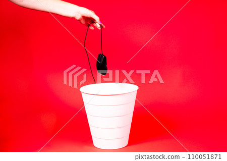 A computer mouse with a wire is thrown into the office wastebasket. A computer mouse with a wire is thrown into the office wastebasket. 110051871