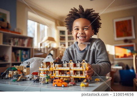 AI-generated content. A little African American boy sits at the table in his cozy room and plays with a construction set. Happy smart kid assembling a model of toy city with houses, cars and people 110054656