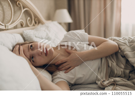 Young woman suffering with headache flu ill sick disease cold at home indoor lying on bed top view Young woman suffering with headache flu ill sick disease cold at home indoor lying on bed top view 110055515