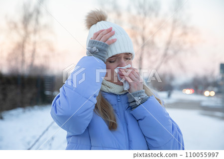 Close-up of a silhouette of a girl who is sick and puts a handkerchief to her nose. Close-up of a silhouette of a girl who is sick and puts a handkerchief to her nose. 110055997