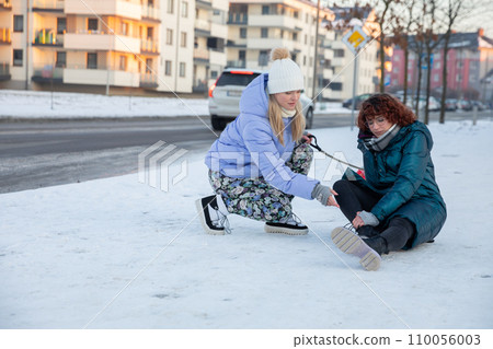 The girl fell on slippery ice during a winter walk. The girl fell on slippery ice during a winter walk. 110056003