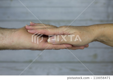 Male hand of the older husband lies on the palm of the adult wife. Concept of love and relationships at age, close photo of hands 110056471