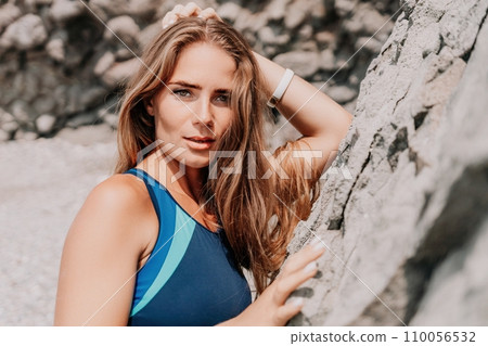Woman summer travel sea. Happy tourist in blue bikini enjoy taking picture outdoors for memories. Woman traveler posing on the beach surrounded by volcanic mountains, sharing travel adventure journey 110056532