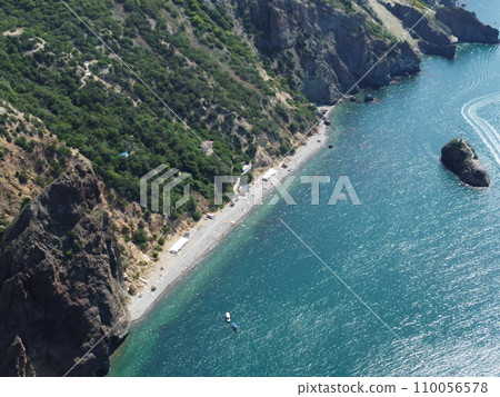 Aerial view from above on calm azure sea and volcanic rocky shores. Small waves on water surface in motion blur. Nature summer ocean sea beach background. Nobody. Holiday, vacation and travel concept 110056578
