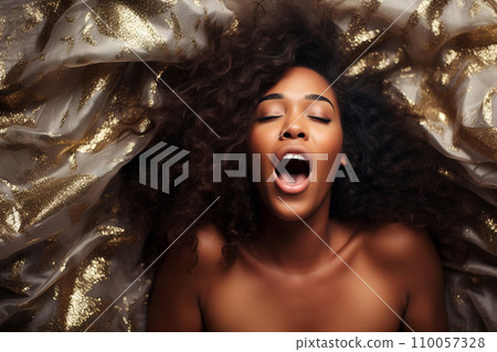 African american woman having orgasm. Woman with open mouth and closed eyes enjoying sex lying among flying glitter and sparkles as a symbol of orgasm. Sexual experience, masturbation, cunnilingus. African american woman having orgasm. Woman with open mouth and closed eyes enjoying sex lying among flying glitter and sparkles as a symbol of orgasm. Sexual experience, masturbation, cunnilingus. 110057328
