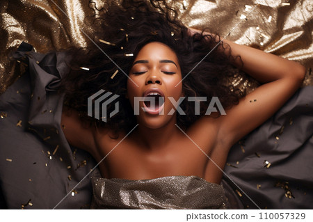 African american woman having orgasm. Woman with open mouth and closed eyes enjoying sex lying among flying glitter and sparkles as a symbol of orgasm. Sexual experience, masturbation, cunnilingus. 110057329