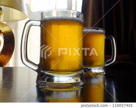 Two full glasses of classic light beer with fresh foam detailed    110057485