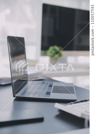 Asian Business woman using calculator and laptop for doing math finance on an office desk, tax, report, accounting, statistics, and analytical research concept 110057591