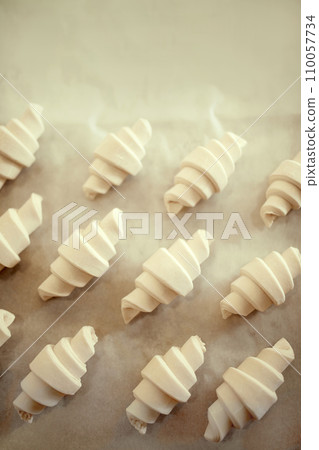 Top view shot, lay out sweet or savory pastries, croissant dough pieces on wooden table covered with parchment. Concept of recipes and cooking. 110057734