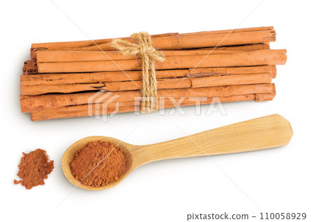 Cinnamon sticks with powder in wooden spoon isolated on white background with full depth of field. Top view. Flat lay. 110058929