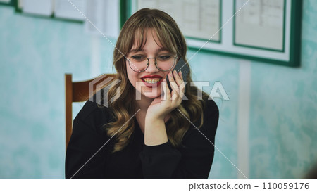 A school girl playing cards with her friends and smiling. 110059176
