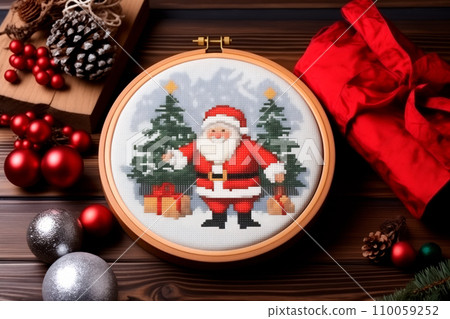 A framed embroidered christmas card with ornaments and candles on wooden table. Winter background with pine twigs A framed embroidered christmas card with ornaments and candles on wooden table. Winter background with pine twigs 110059252