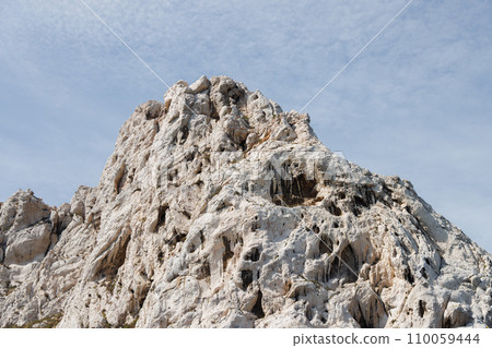 Sandy rock against a backdrop of blue sky. Sandy rock against a backdrop of blue sky. 110059444